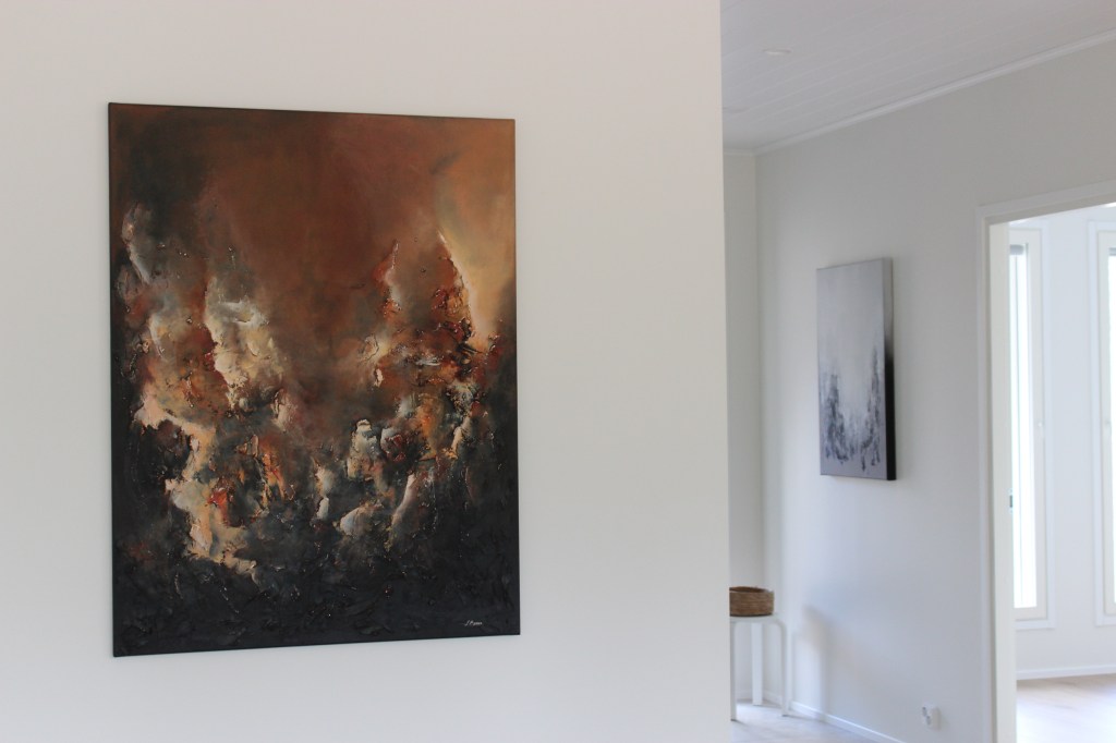 Ruskea abstrakti teos kodin seinällä.